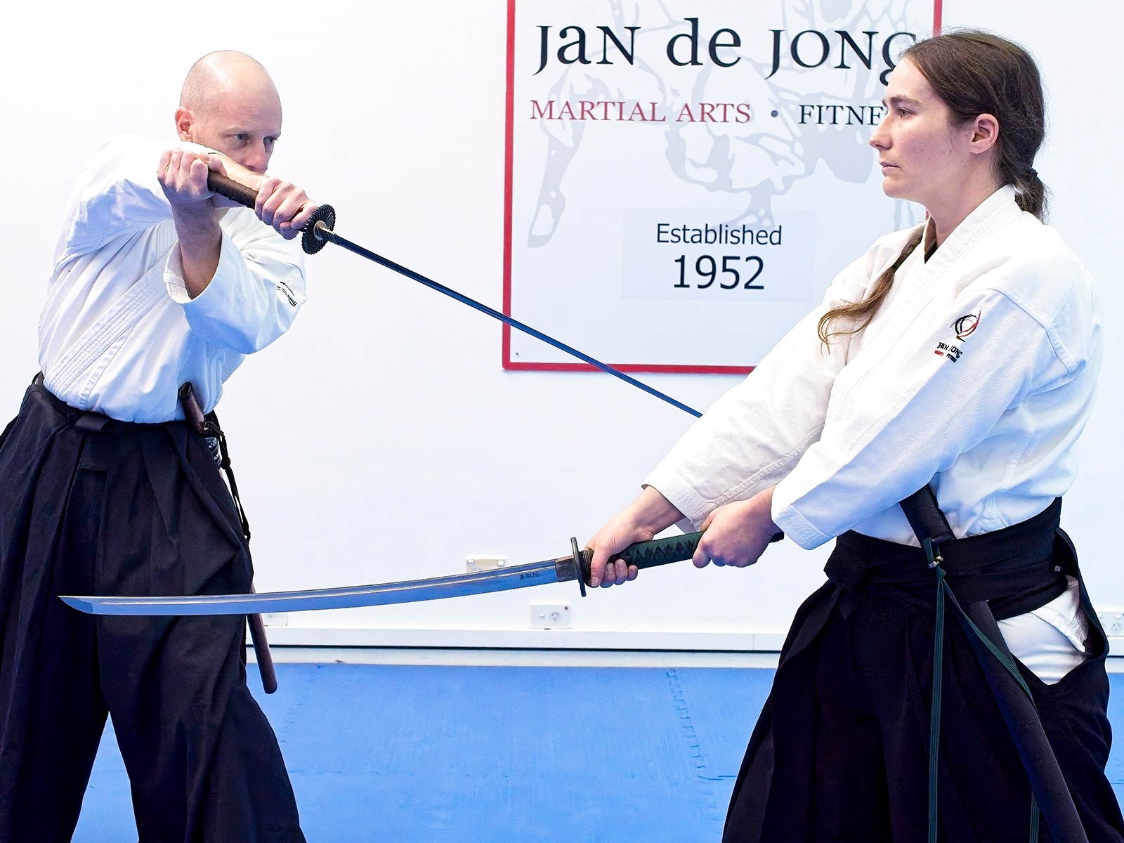 Two practitioners clashing wooden swords during kenjutsu partner practice