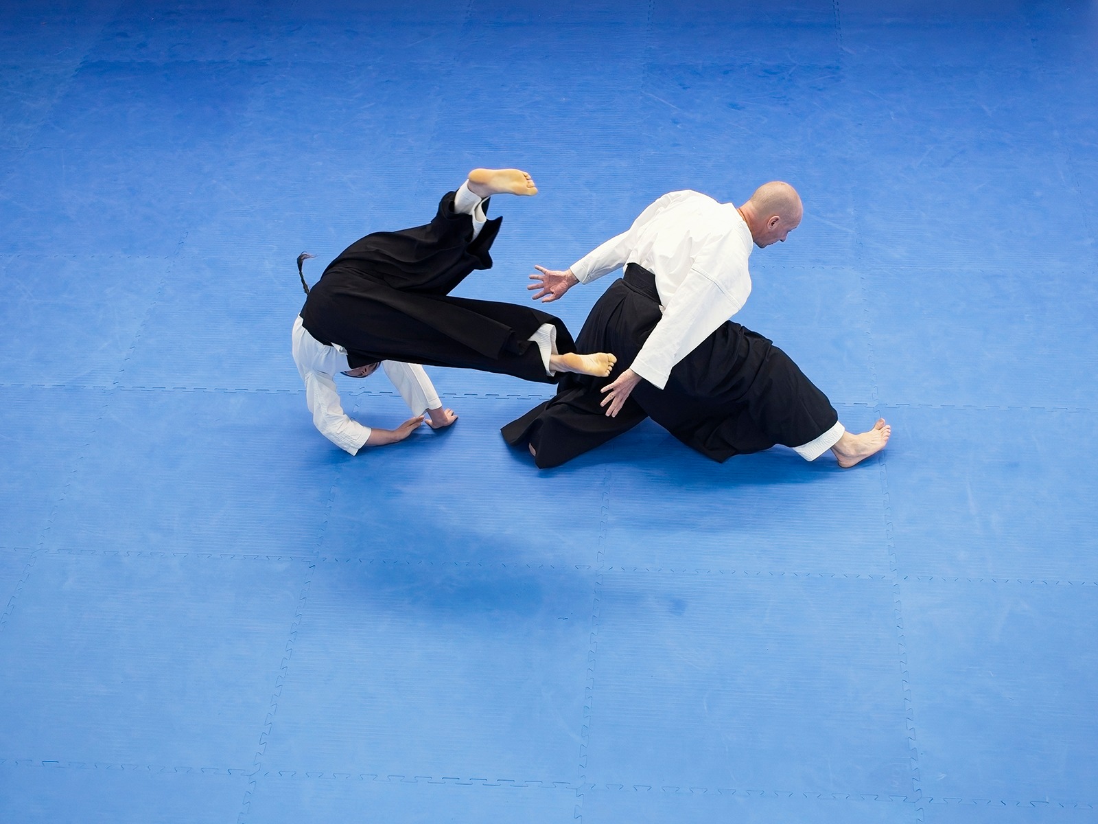 Aikido practitioner performing breakfall from overhead view