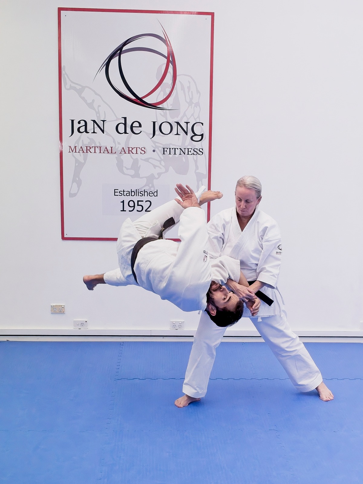 Female instructor demonstrating jujutsu throwing technique with student