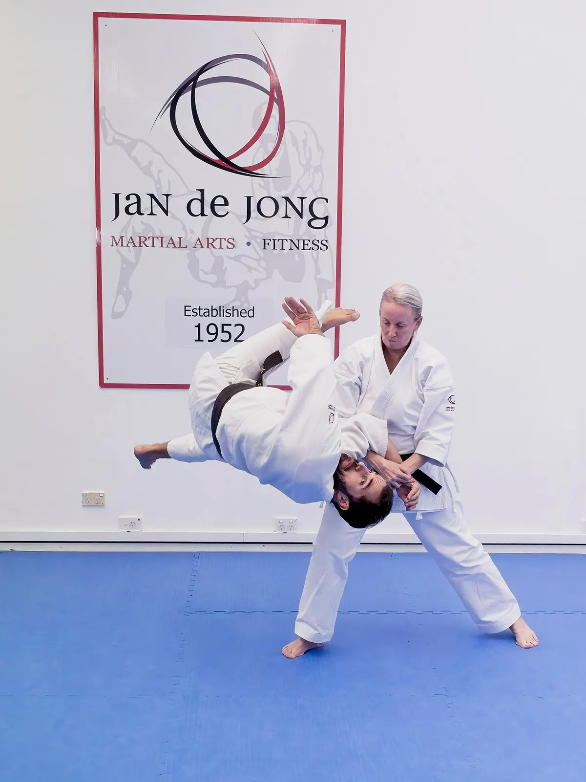Female instructor demonstrating jujutsu throwing technique with student